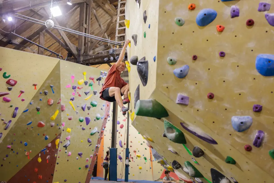 Climber reaching across a bouldering wall