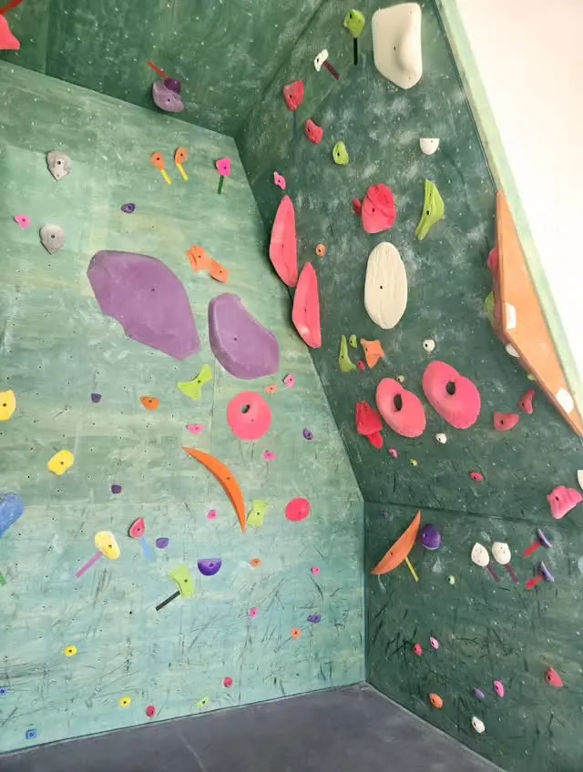 Corner of the bouldering wall with large purple volumes