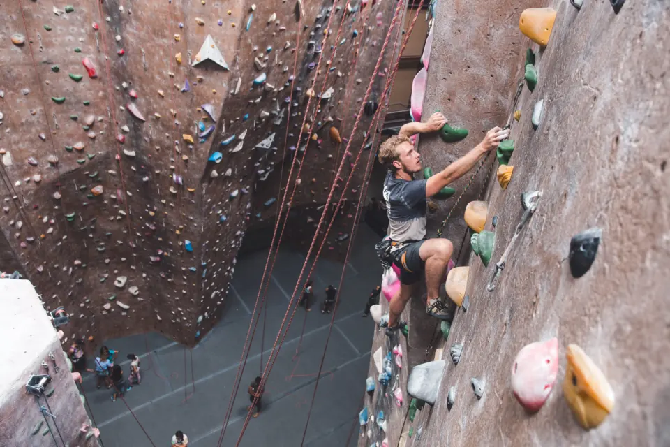 Climber high on a featured wall above the ropes area