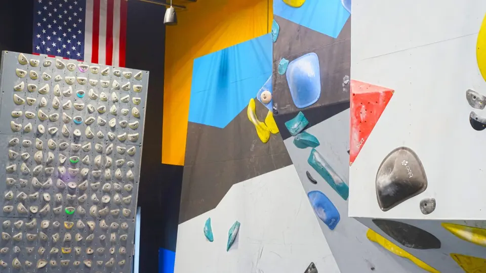 Kilter Board beside the painted bouldering walls