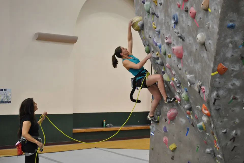 Climber on a top rope with a belayer at the Rex climbing wall