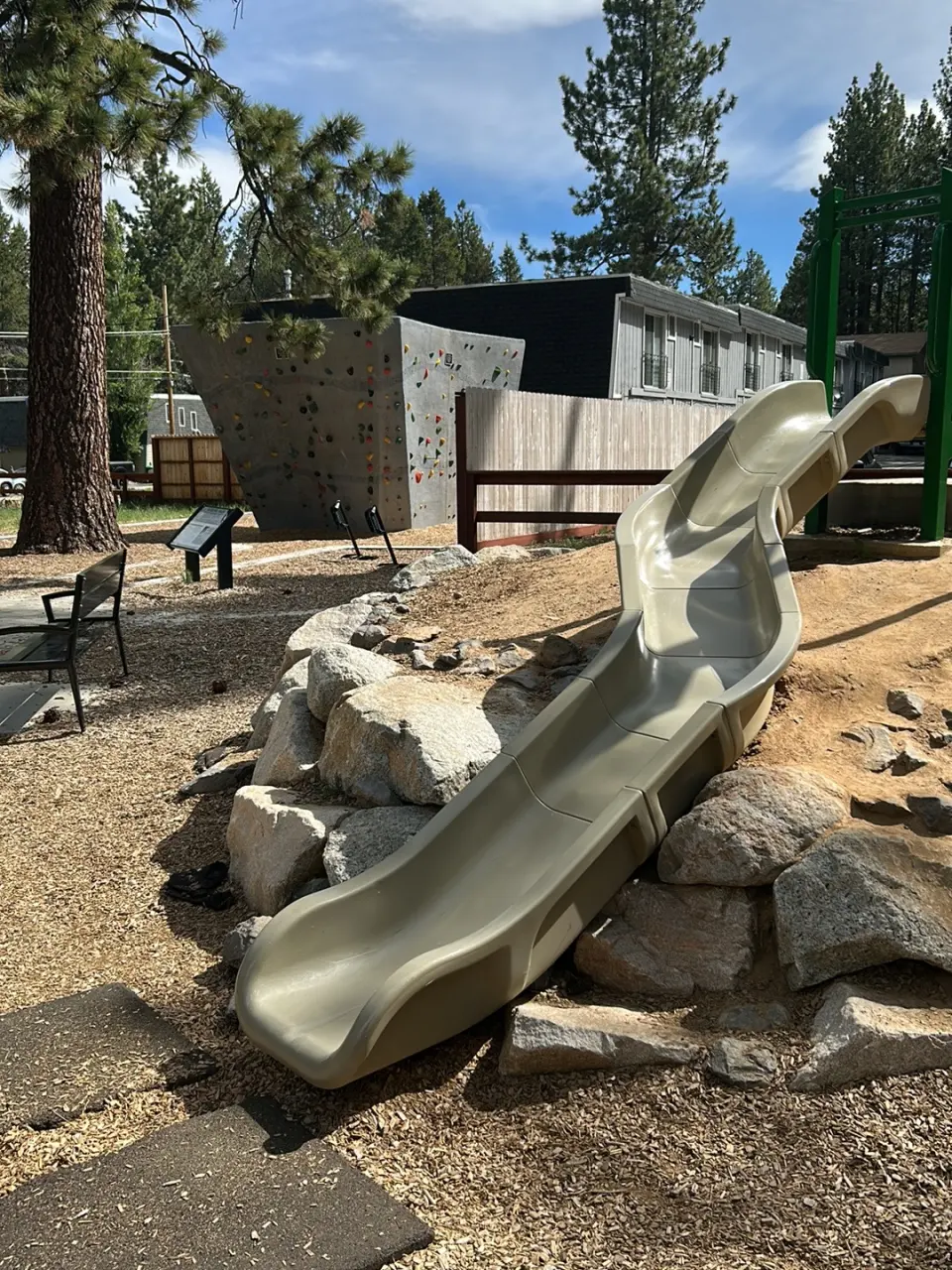 Slide set into a rock bank, with the climbing boulder behind