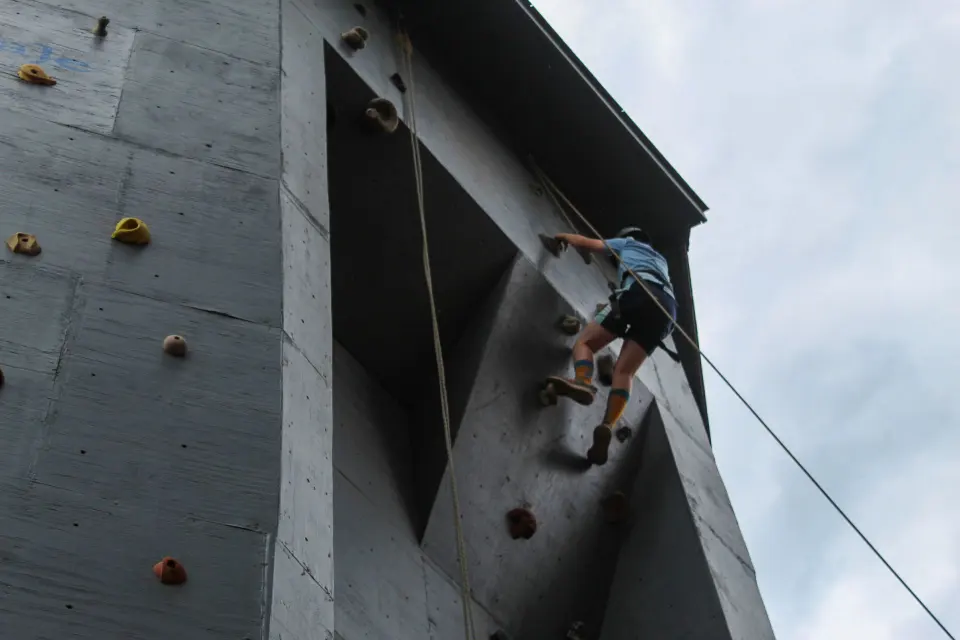 Climber high on the outdoor climbing tower