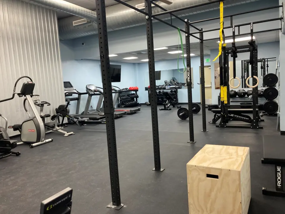 Fitness room with a pull-up rig, cardio machines and plyo box