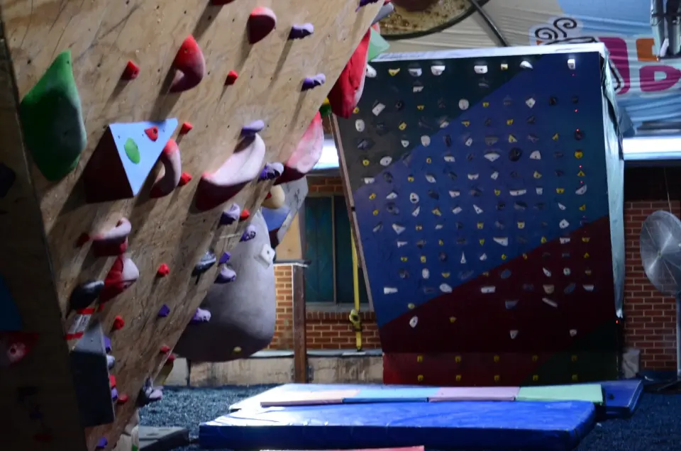 Wooden overhang and a blue and red wall above crash mats