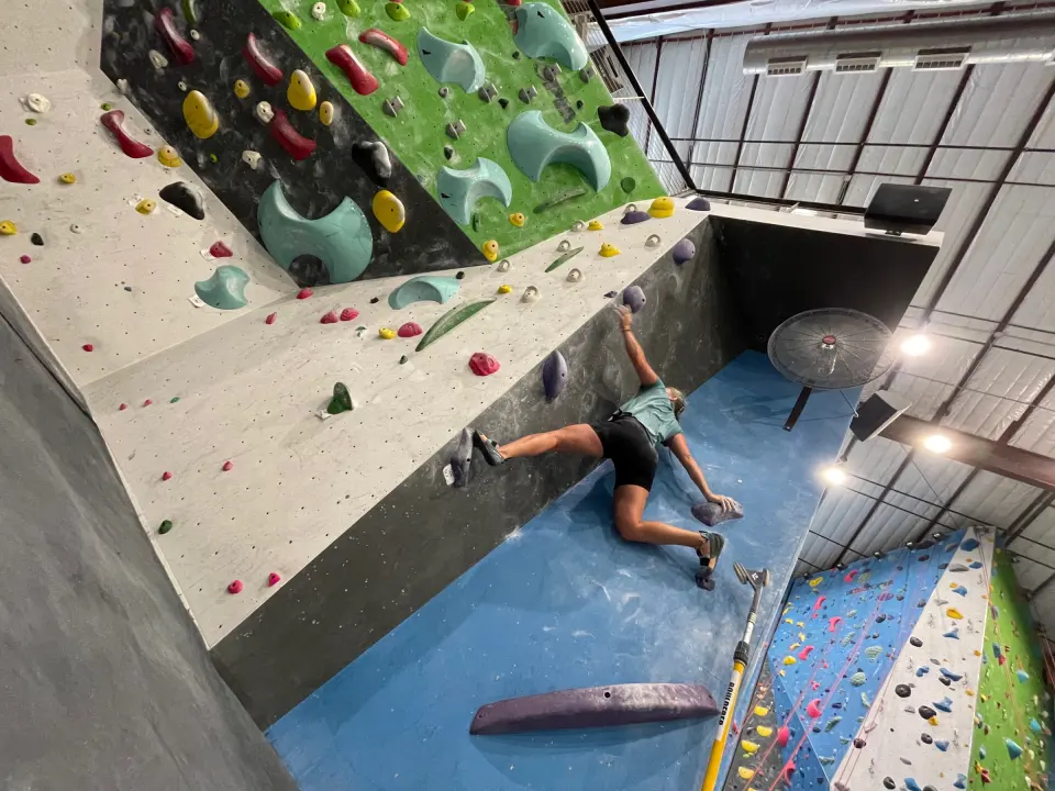 Climber on a steep corner boulder problem