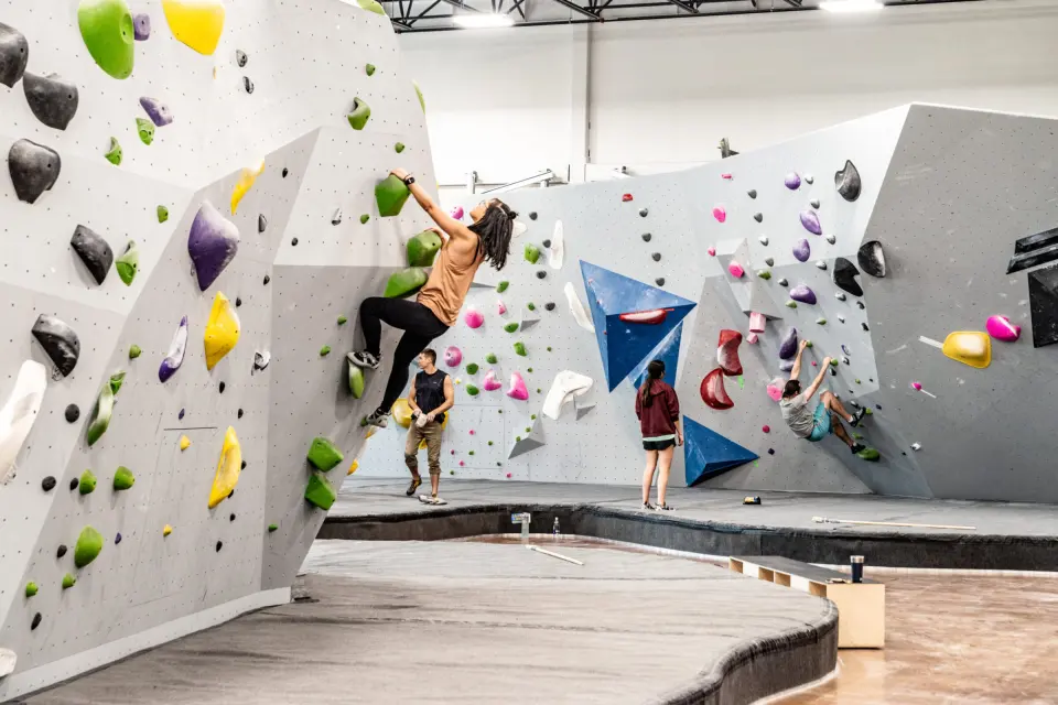 Climbers on the bouldering walls with blue volumes