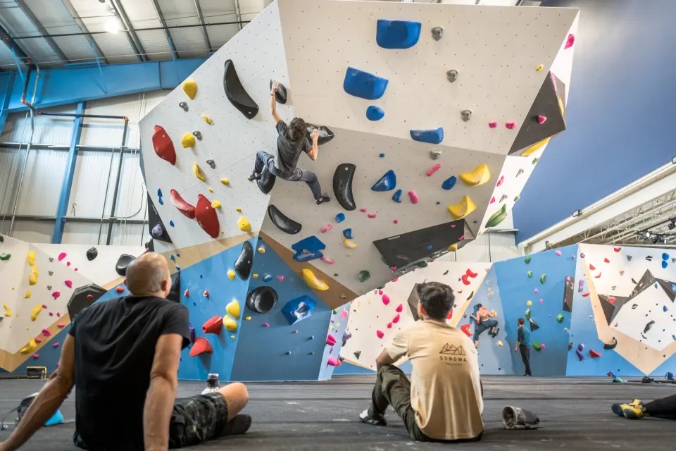 Climbers resting below an overhanging bouldering wall