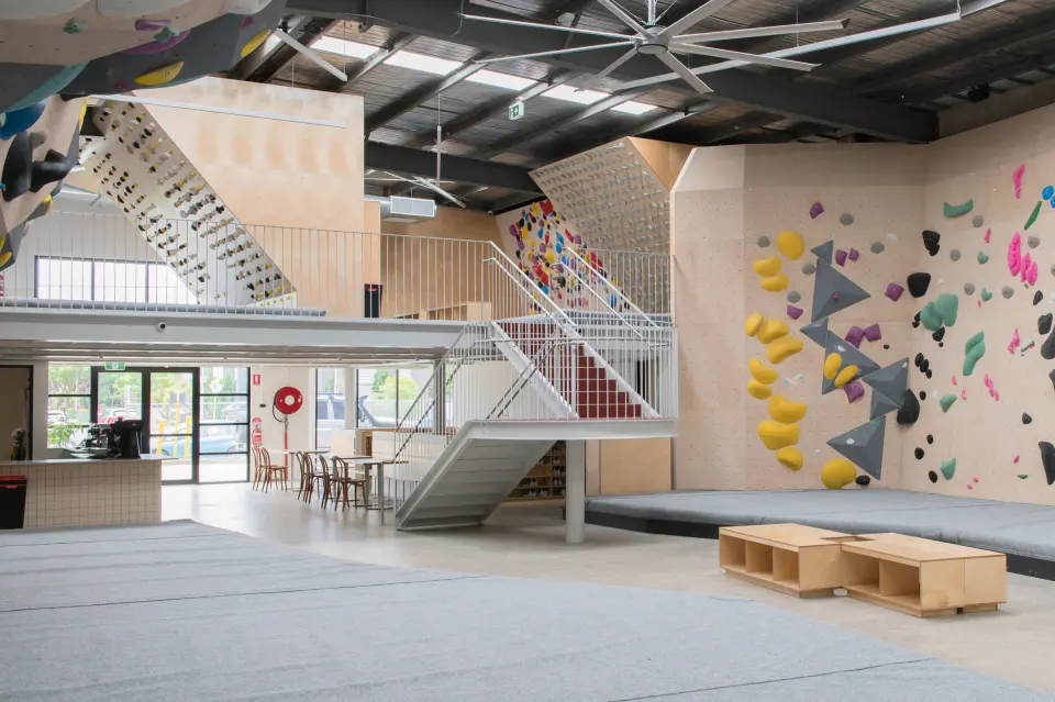 Bouldering hall with the mezzanine training floor and café behind