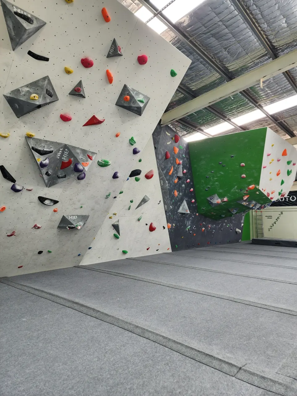 Volumes and holds on an angled white wall, with the green overhang behind