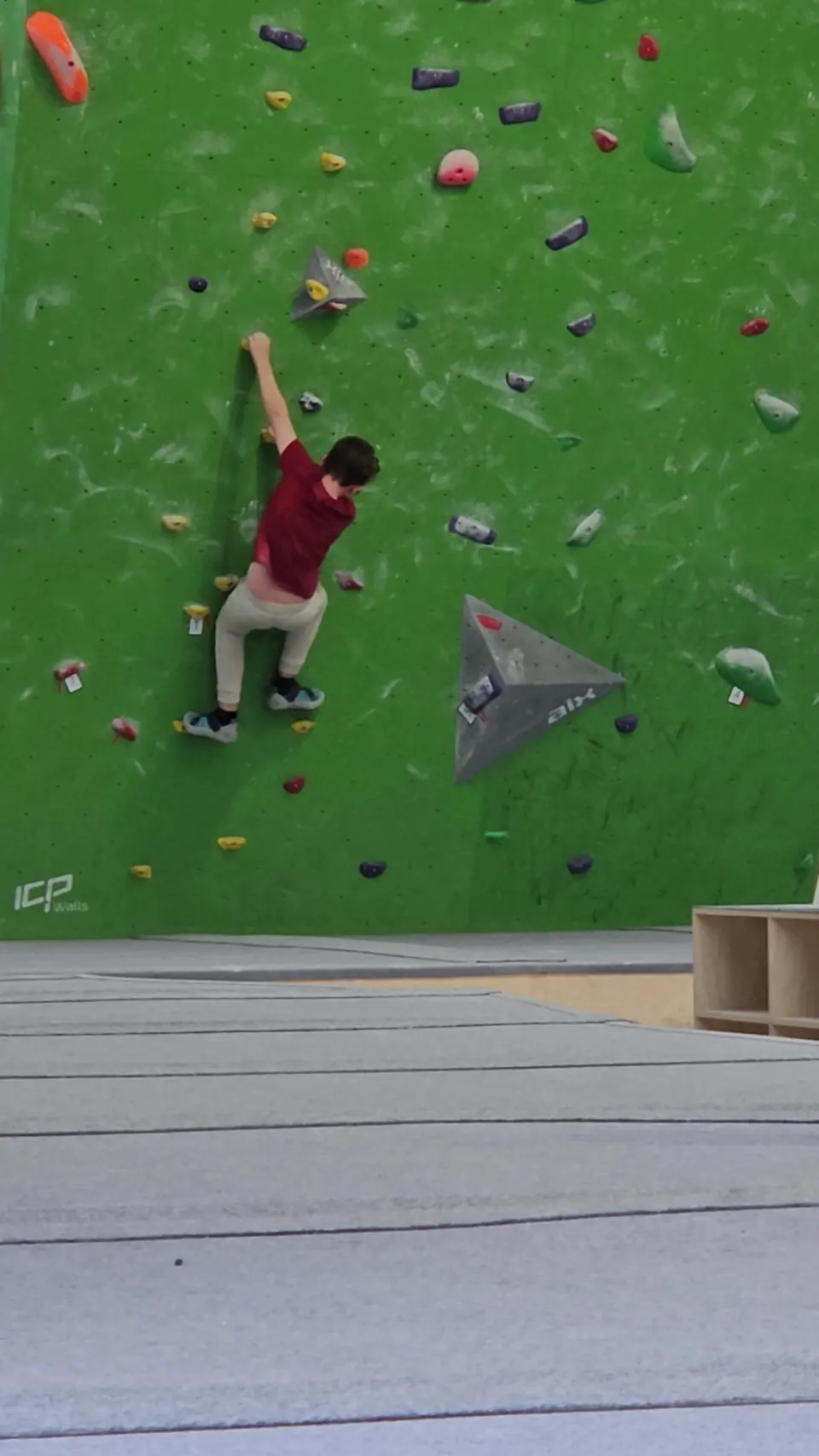 A climber on the green vertical wall