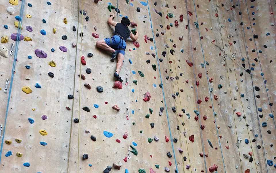Climber high on the tall top-rope wall