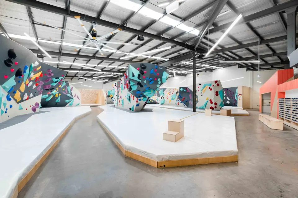 Bouldering hall with white padded floors and colourful walls