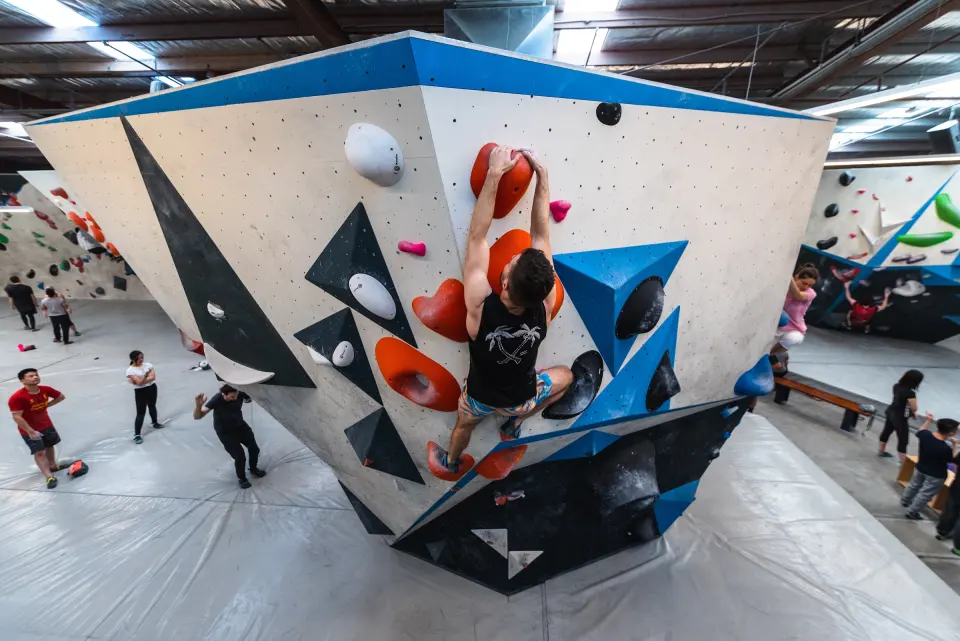 Climber on the freestanding boulder in the main bouldering hall, seen from above
