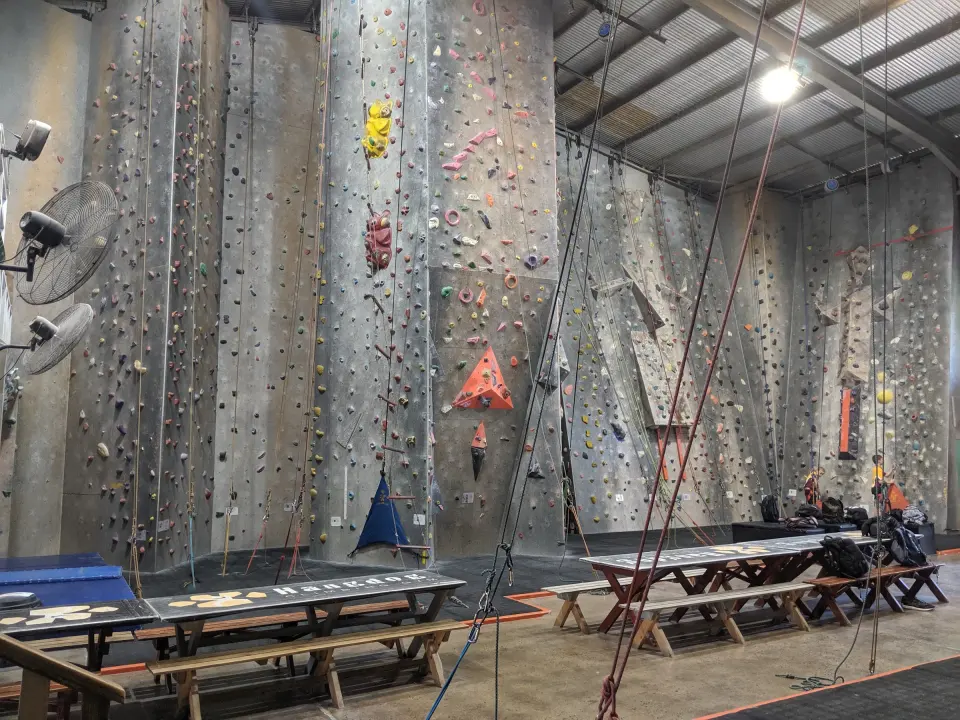 The main hall's tall roped walls above the Hangdog picnic tables