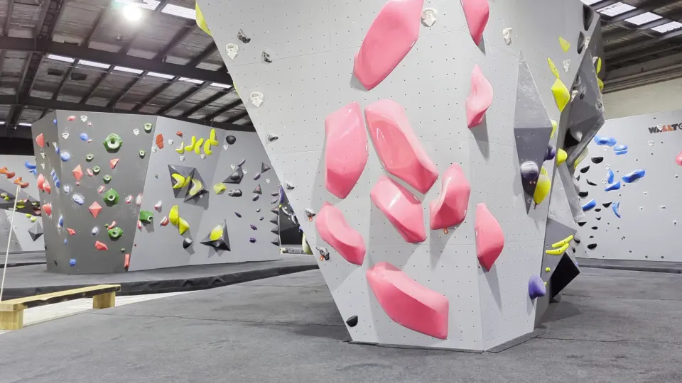 An overhanging boulder set with large pink volumes