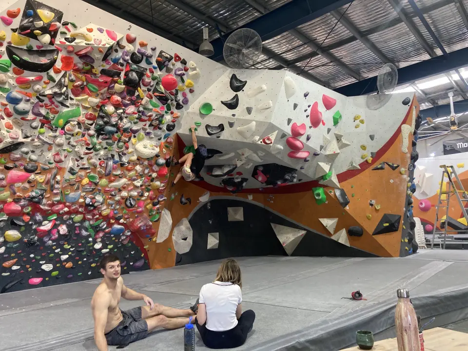 Densely set spray wall beside an overhanging bouldering wall