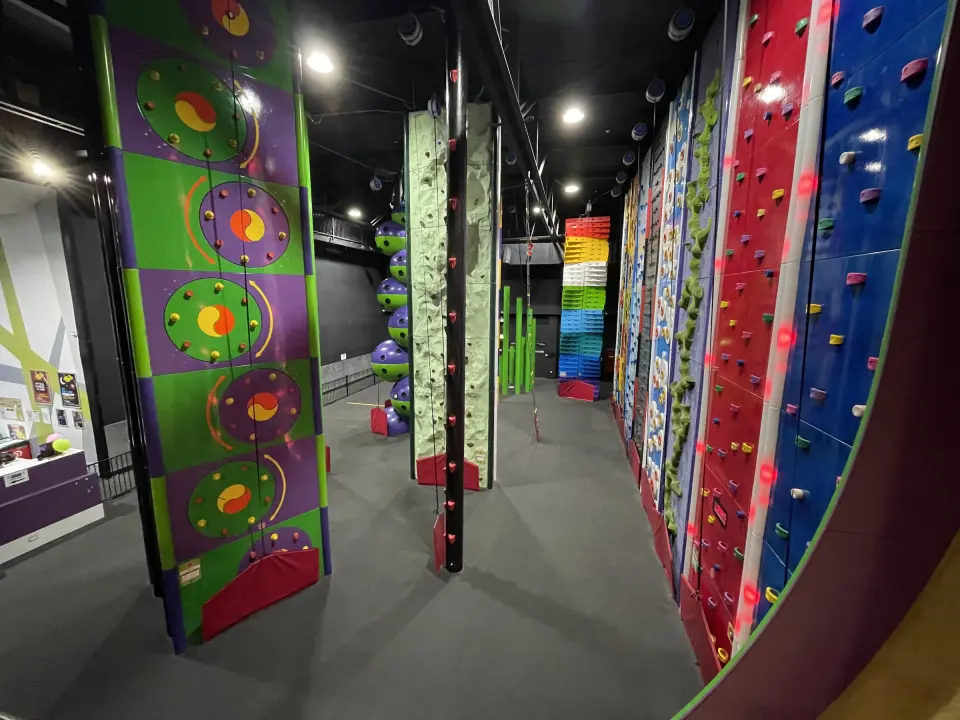 Row of brightly themed auto-belay climbing walls