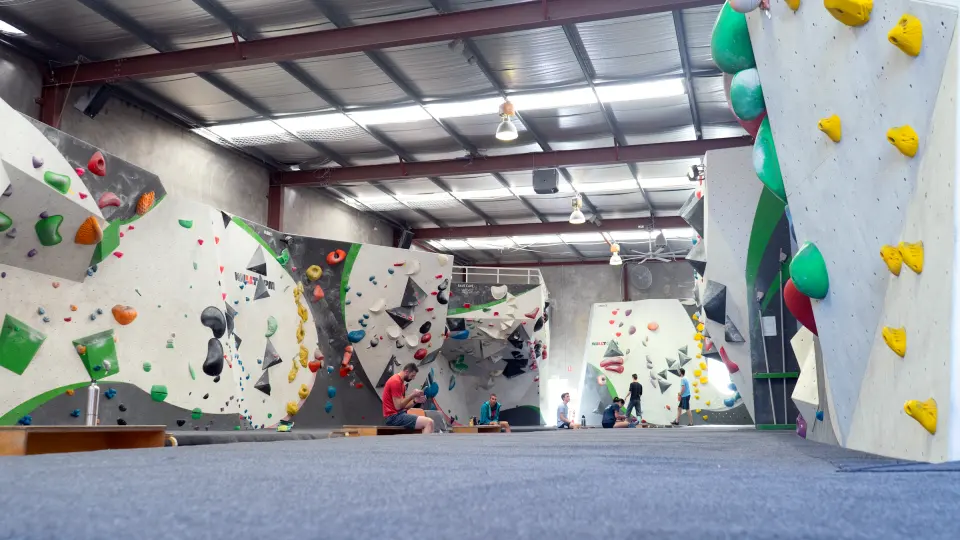 The bouldering hall, with grey and white walls and padded matting