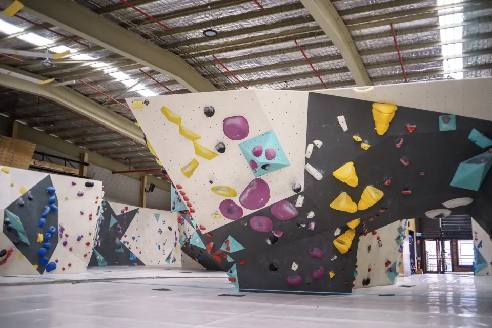 Freestanding boulder with yellow and purple holds in the main hall