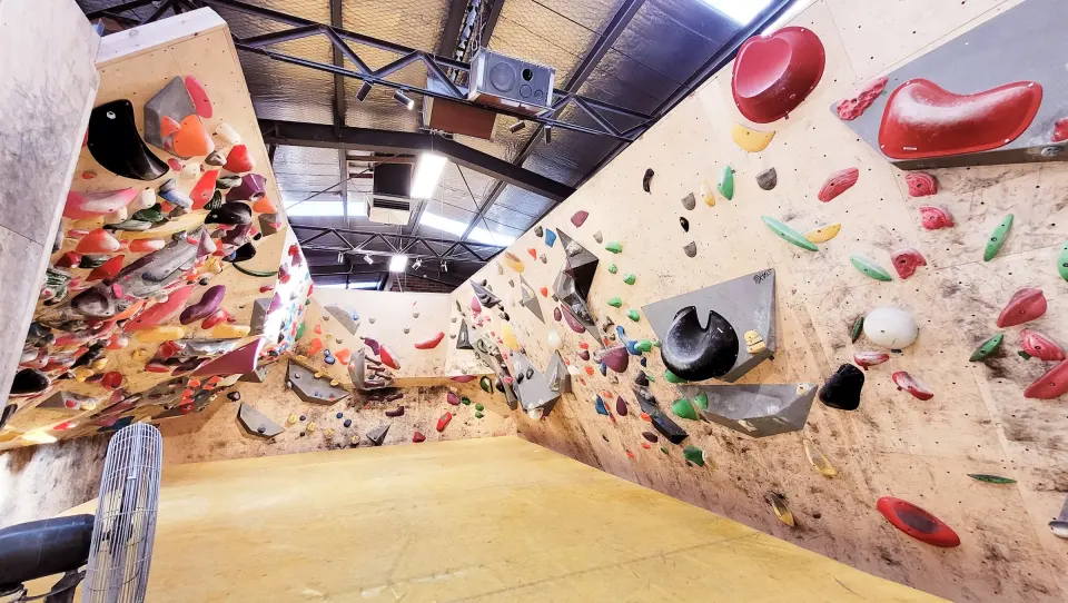 Bouldering walls above yellow matting in the main hall