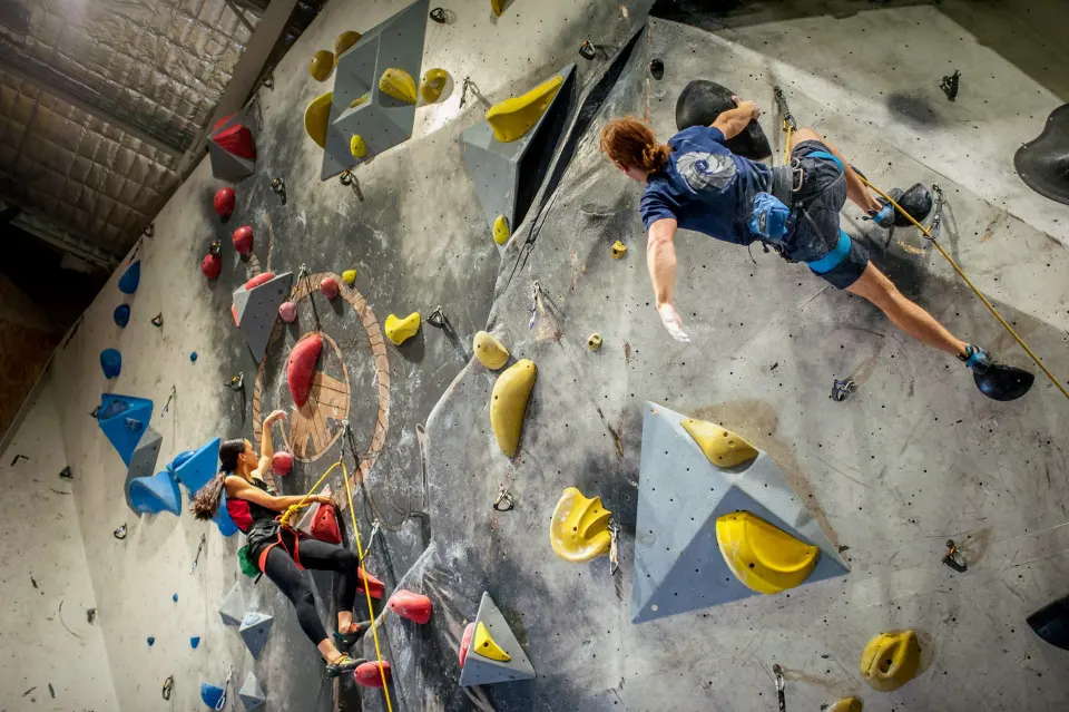 Climbers on the grey wall with yellow volumes