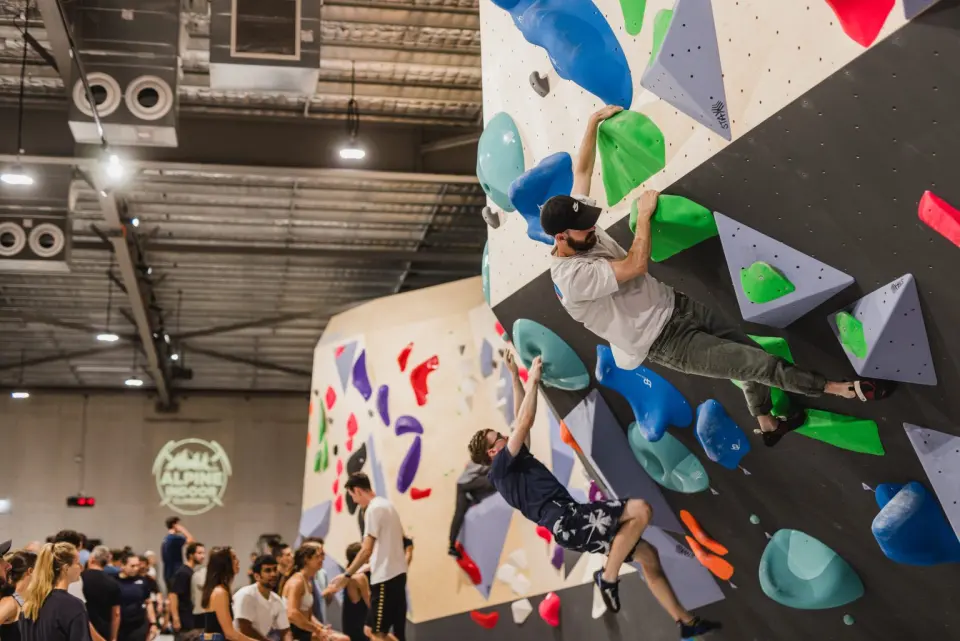 Climbers on the overhang above a crowded floor