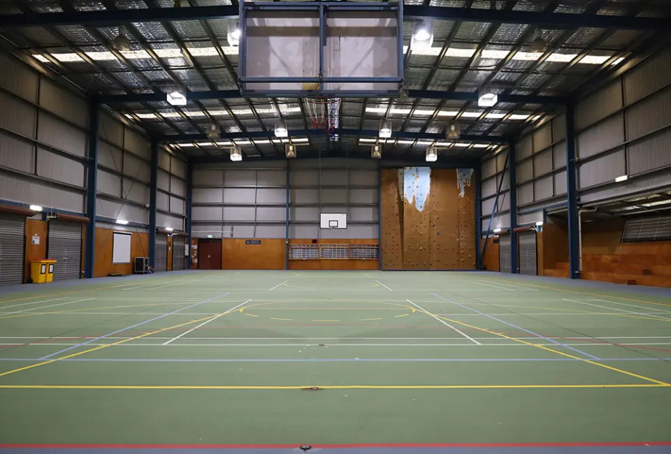 Sports hall with a tall climbing wall at the far end