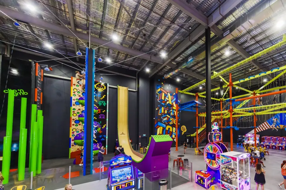 Clip 'n Climb walls, green poles and the drop slide beside the high ropes course