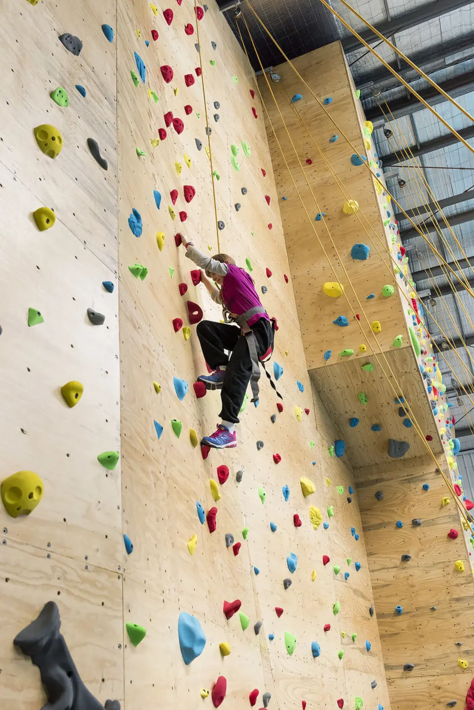 Looking up the full height of the roped wall at a climber