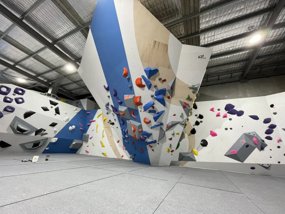 Tall bouldering tower above grey crash mats