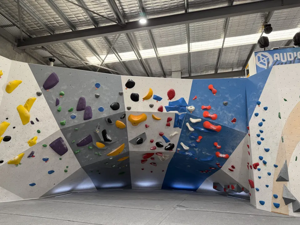 Long bouldering wall with grey and blue panels