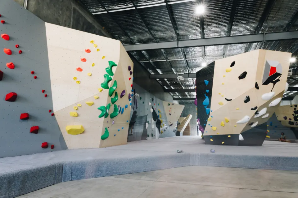 Bouldering hall with plywood walls and the freestanding Dynomite logo boulder