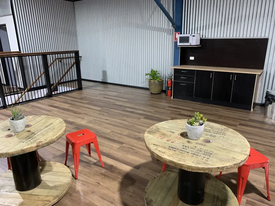 Upstairs party area with cable-reel tables, stools and a kitchenette