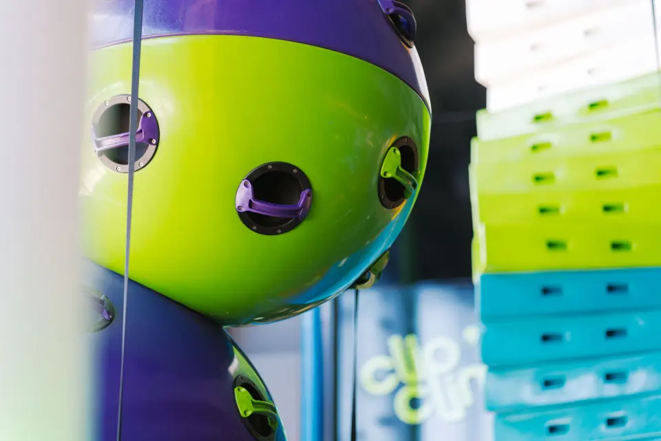 Giant climbing spheres with hand holds next to coloured step-up blocks