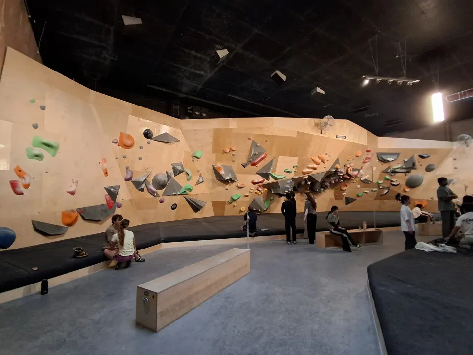 Long run of bouldering walls above the matted floor