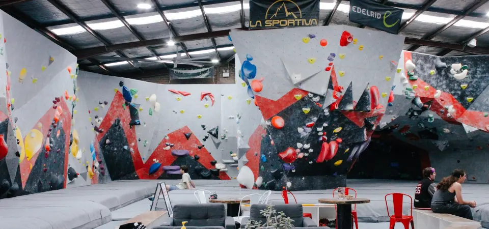 The bouldering hall at Pulse Climbing Gosford, with couches and tables beside the walls