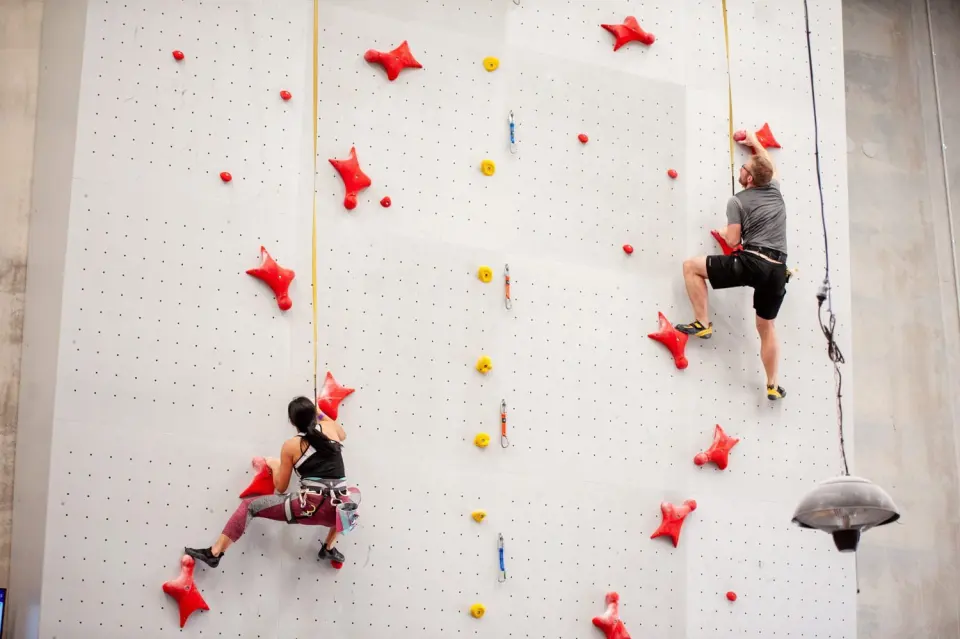 Climbers on the red holds of the speed wall