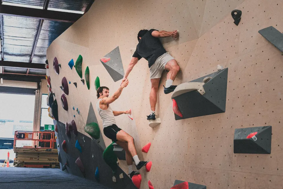Two climbers on a wall with grey volumes
