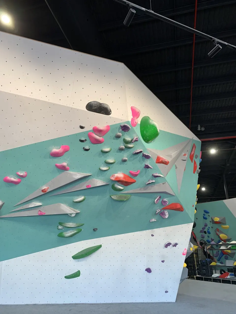 Angled teal wall with grey volumes and colourful holds
