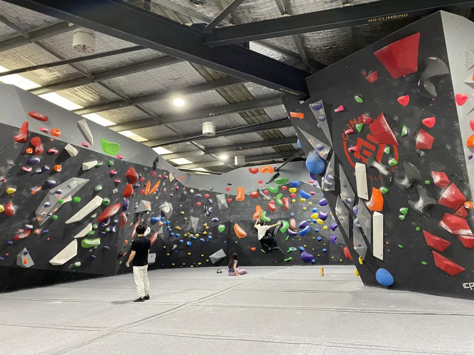 Climbers working problems around the bouldering hall