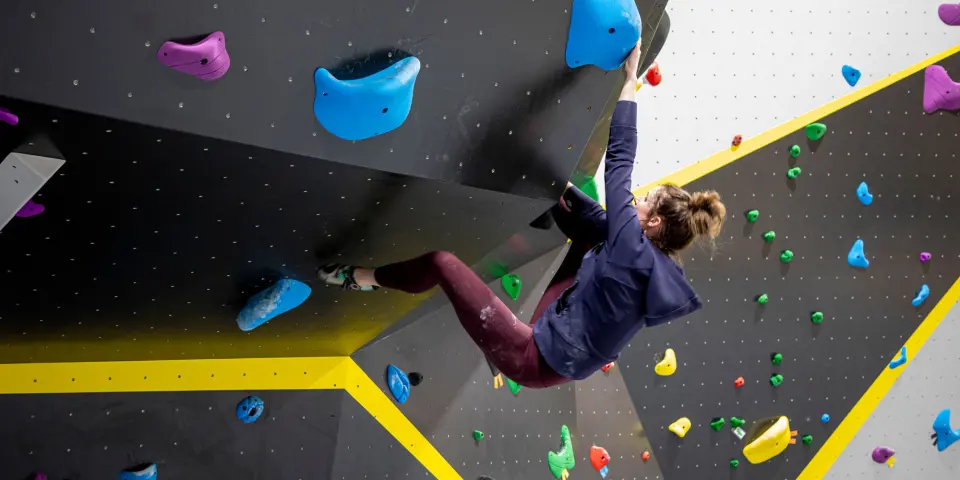 Climber reaching across a steep black overhang