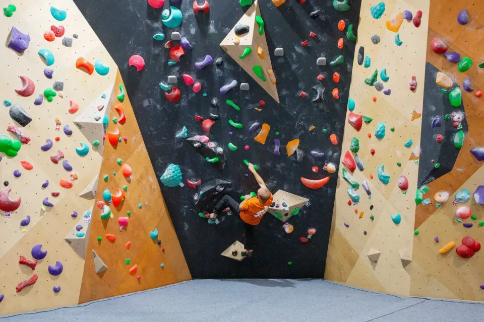 Climber on a black panel between plywood walls