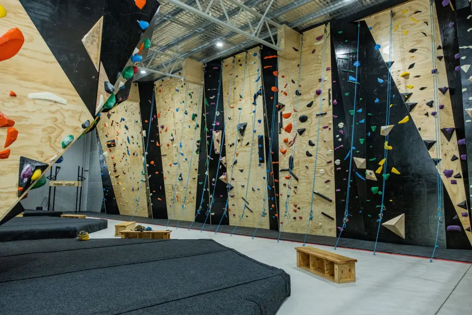 Lead and top-rope walls rising above the bouldering mats