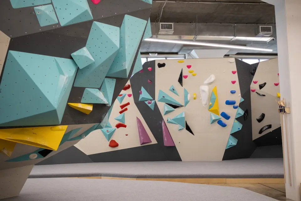 Wall with large teal and yellow volumes above the mats