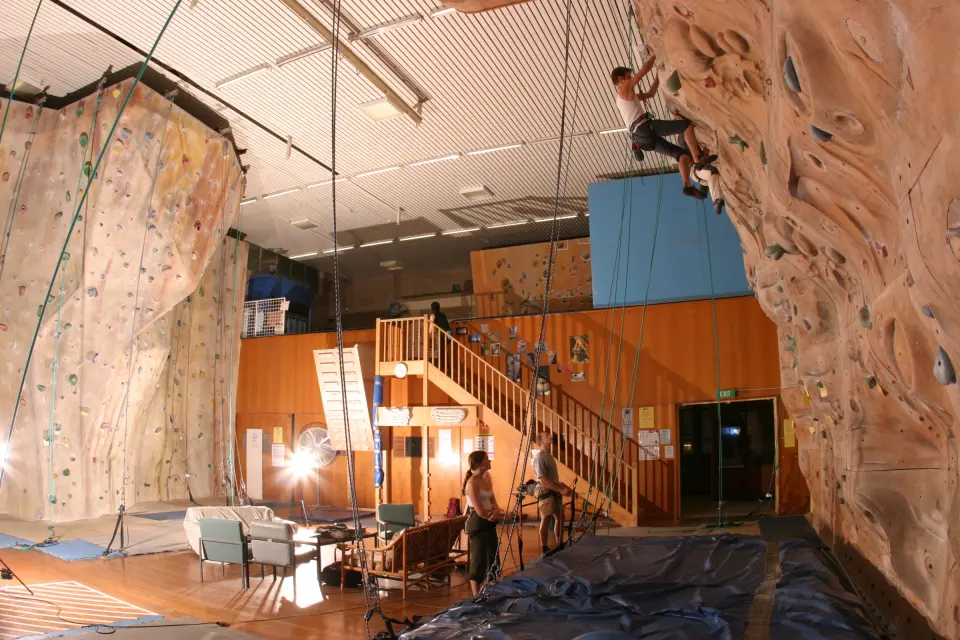 The roped climbing hall with sculpted textured walls and stairs up to the bouldering area