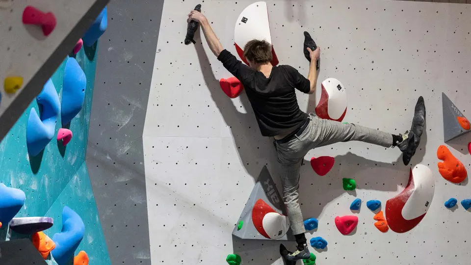 Climber high-stepping on a vertical wall