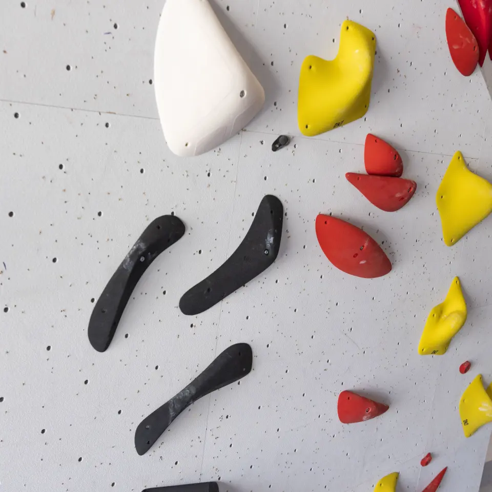 Black, red and yellow holds freshly set on a wall