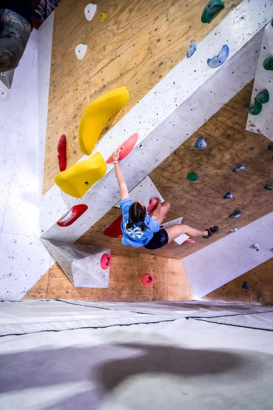Climber on big yellow volumes under a steep overhang