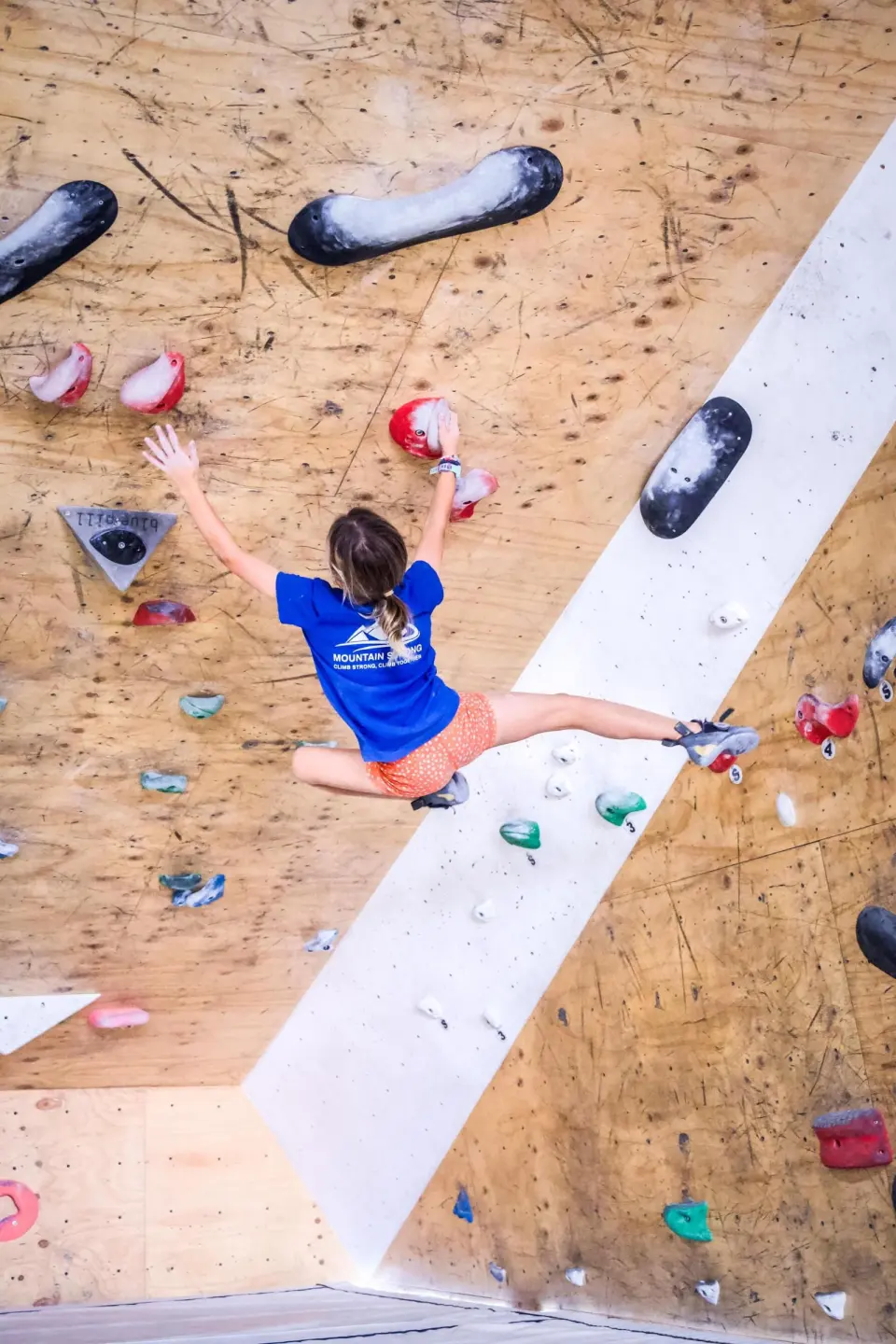 Climber spanning across a plywood wall